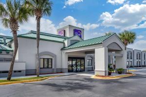 a large white building with palm trees in front of it at Sleep Inn Destin near Miramar Beach in Destin