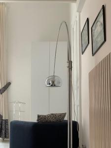 een kamer met een blauwe stoel en een lamp bij B&B Neapolis Bellini in Napels