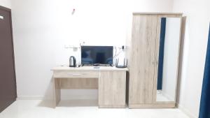 a wooden desk with a mirror and a television at Dar Al-Jwharah in Duqm