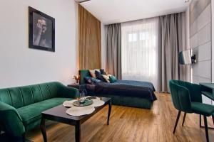 a living room with a green couch and a table at Apartament czarny z jacuzzi in Krakow