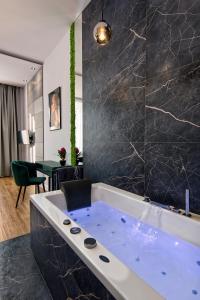 a large bath tub in a room with a table at Apartament czarny z jacuzzi in Kraków +15 photos
