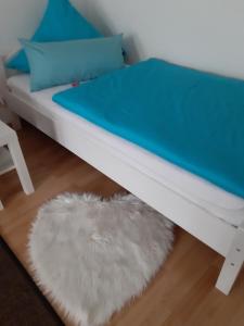 a bed with a blue mattress and a white rug at City Apartment Tübingen-Lustnau in Tübingen