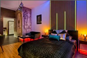 a bedroom with a bed with purple and green lighting at Apartament czarny z jacuzzi in Kraków