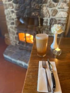 una mesa con un tenedor y una taza de café y una vela en The Trooper Inn, en Petersfield