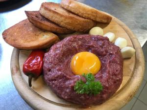 a plate of food with a hamburger and bread and eggs at Inovecká Chata in Trenčianske Jastrabie