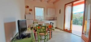 Appartamento Il Mandorlo في كابوليفيري: مطبخ مع طاولة وتلفزيون في الغرفة