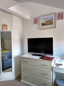 een slaapkamer met een dressoir en een flatscreen-tv bij The Lakes B and B in Ambleside