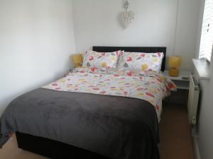 1 dormitorio con cama con edredón y almohadas grises en Lanhydrock View en Bodmin