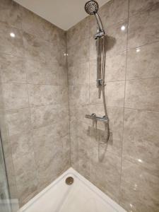La salle de bains est pourvue d'une douche avec un pommeau de douche. dans l'établissement The Wincheap B&B, à Canterbury