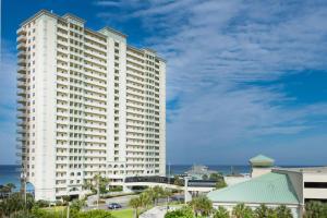 un grande edificio bianco con l'oceano sullo sfondo di Celadon 1902 "Aloha No Ka Oi" a Panama City Beach