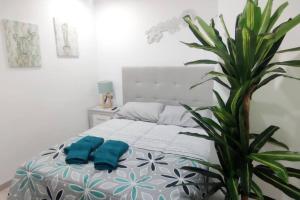 a bedroom with a bed with a plant next to it at - LUJO - Parking, Maquina Arcade, Wifi y Netflix in Oviedo