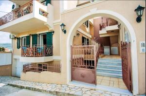un edificio con 2 balcones y una puerta y escaleras en Elena's apartment 3 en Argostoli