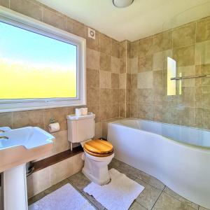 y baño con bañera, aseo y lavamanos. en Ta Mill Cottages & Lodges - Meadowview Chalet 1 en Launceston
