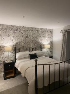 a bedroom with a large bed with floral wallpaper at Abbey Green Farm in Wem