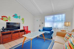 a living room with a tv and a couch and a table at Gulf Crest #7 in Destin