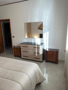 a bedroom with a bed and a dresser with a mirror at Casa Norma in Sottomarina
