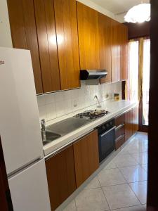 a kitchen with wooden cabinets and a sink and a stove at Casa Norma in Sottomarina