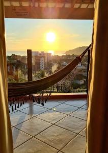 eine Hängematte auf einem Gebäude mit Sonnenuntergang in der Unterkunft Pousada Vista Dell Mar in Ubatuba