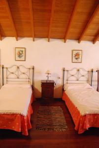 a bedroom with two beds and a wooden ceiling at Casa Abuela Estebana in Isora
