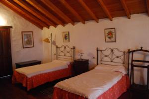 a bedroom with two beds and a wooden ceiling at Casa Abuela Estebana in Isora