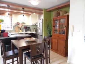 a kitchen with a wooden table and chairs at Bel Appartement avec terrasse proche des plages in Saint-Gilles les Bains