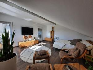 a bedroom with a bed and a flat screen tv at Pflaumers Ferienwohnung in Eppingen