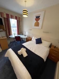 a bedroom with a bed with two towels on it at Victoria House - Self Catering Quiet Guesthouse - Adult Singles and Couples Only in Blackpool