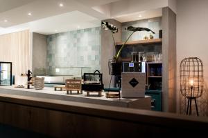 a living room with a counter with a table at Hotel La Source Epen in Epen