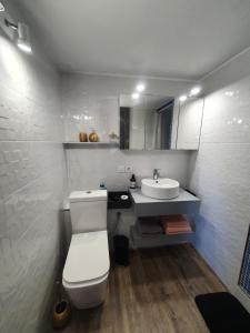 a bathroom with a white toilet and a sink at La cueva inès in Almería