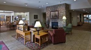 a lobby with a living room with a fireplace at Coshocton Village Inn & Suites in Coshocton