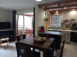 a kitchen and dining room with a table and chairs at Bel Appartement avec terrasse proche des plages in Saint-Gilles les Bains