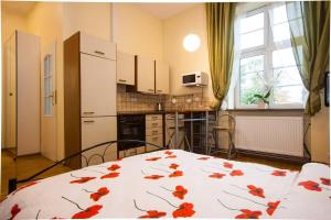 a kitchen with a white table with red flowers on it at Słowiańska 4 in Szczawno-Zdrój