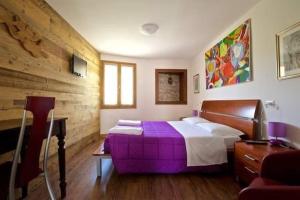 a bedroom with a purple bed in a room at Le Perine 6 in Valdobbiadene