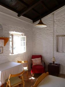 a room with a bed and a chair and a table at Tsoupis Farm House in Agní