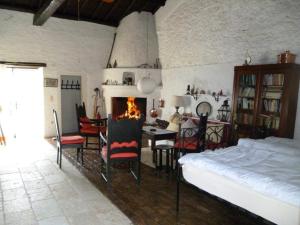 a bedroom with a bed and a table and a fireplace at Tsoupis Farm House in Agní