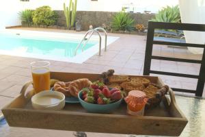 - un plateau de produits pour le petit-déjeuner et un verre de jus d'orange dans l'établissement Villa Tabaiba Playa Blanca Lanzarote, à Playa Blanca