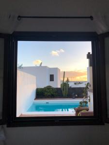 a view of a swimming pool through a window at Villa Tabaiba Playa Blanca Lanzarote in Playa Blanca