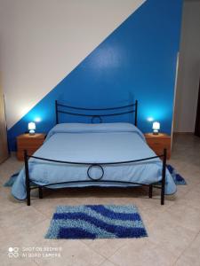 Schlafzimmer mit einem Bett mit blauer Wand in der Unterkunft Da Rosy in Partinico