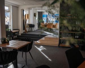 een restaurant met tafels en stoelen en een eetkamer bij Hotel Beatrix in De Koog