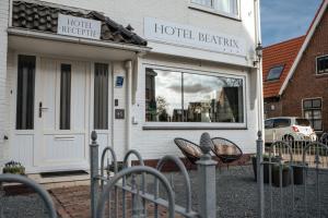 un bâtiment de l'hôtel bellingen avec une clôture devant lui dans l'établissement Hotel Beatrix, à De Koog