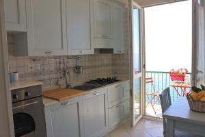 a kitchen with white cabinets and a stove top oven at Casa Colombo in Vietri sul Mare