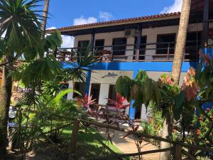 a building with palm trees in front of it at Pousada Ponta da Baleia in Barra Grande