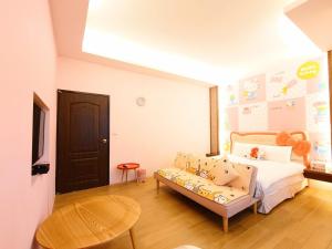 una camera da letto con un letto e un divano in una stanza di Cat Mia Hostel a Città di Hualien Altre 10 foto