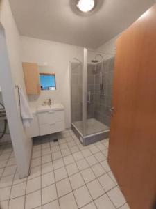 een badkamer met een douche en een wastafel bij Bright appartment in Egilsstadir