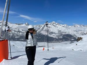 uma mulher em pé no topo de uma montanha coberta de neve em Ca del Forno St Moritz em Maloja