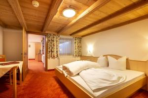 a bedroom with a large bed with a wooden ceiling at Hotel Garni Tyola in Ischgl