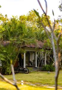 una casa con una bicicleta estacionada frente a ella en Seclude Kerala, Marari Sands, en Mararikulam