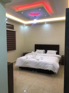 1 dormitorio con 1 cama grande y techo rosa en Authentic boutique, en Wadi Musa