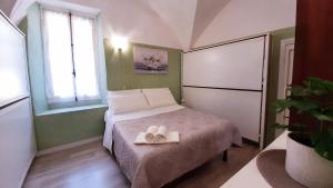 een kleine slaapkamer met een bed met twee handdoeken erop bij Casa Ninnì Sanremo in Sanremo