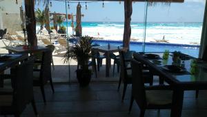 um restaurante com mesas e cadeiras e vista para o oceano em Ocean View Condo em Cancún